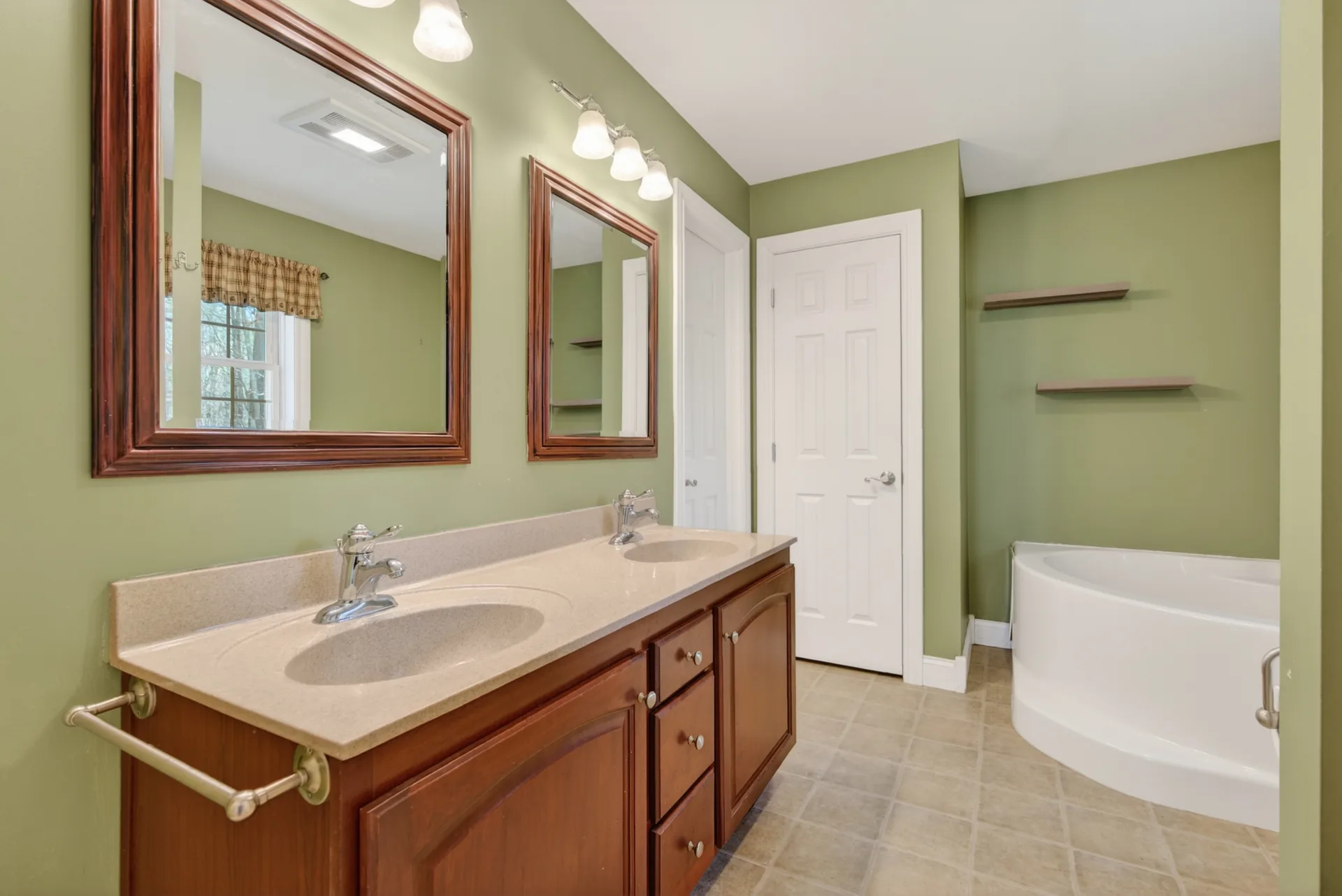 Primary ensuite with double vanity and corner soaking tub