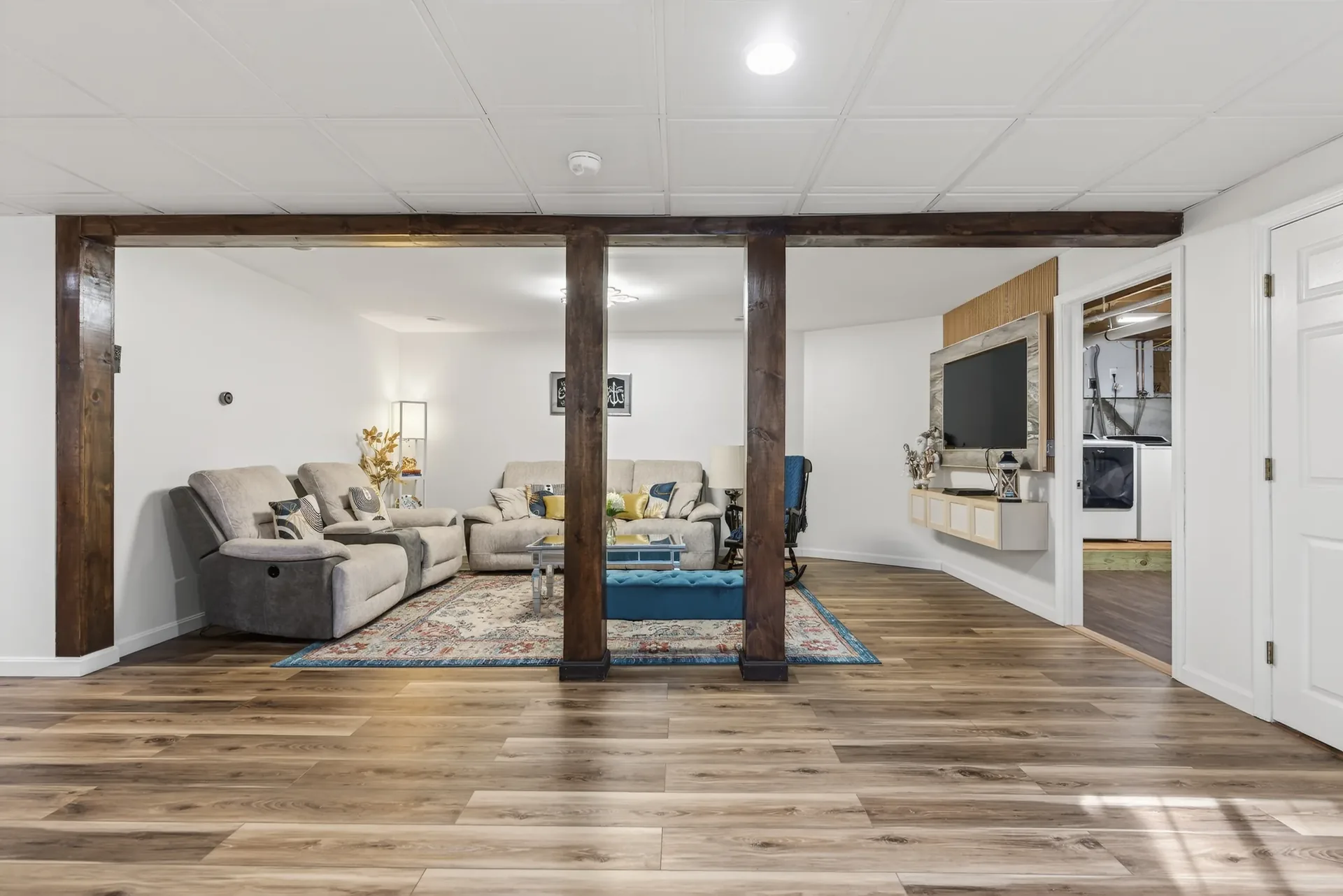 Lower-level family room staged with media wall and beams