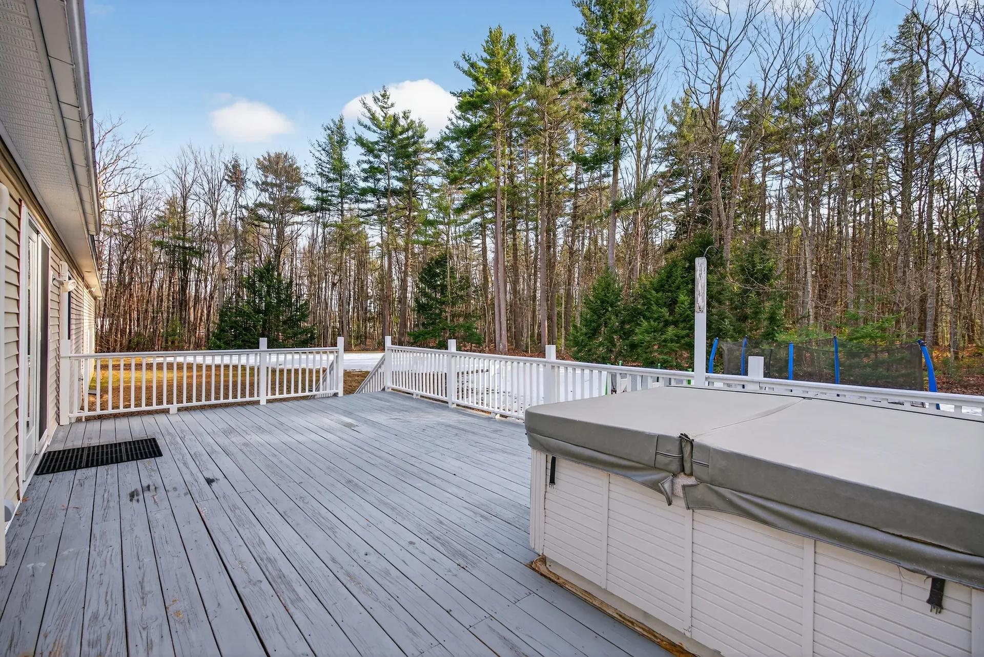 Deck with hot tub and woods beyond